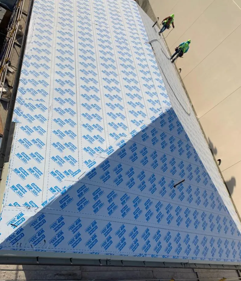 Professional roofers installing underlayment on a metal roof in Amity